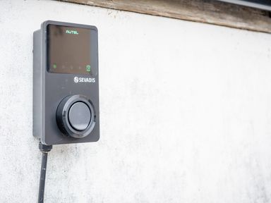 A black device with a circular dial mounted on a white wall at Hoheck in Abersoch