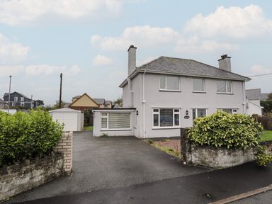 A semi detached house with a driveway and garage at Monarfon in Criccieth