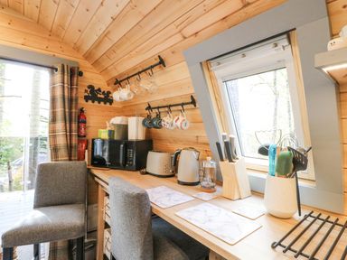 A kitchen area with appliances mugs and utensils on a wooden countertop at Elleric Pods - The Last Resort Fasnacloich near Appin