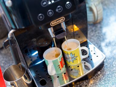 Two coffee mugs under a coffee machine dispensing coffee on a kitchen counter at Smugglers Bodmin Moor St Breward near St Tudy