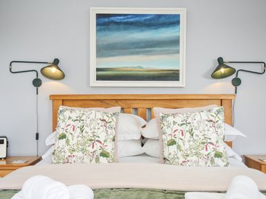 A bedroom with bed and paintings at Smugglers in Bodmin Moor, St Breward near St Tudy
