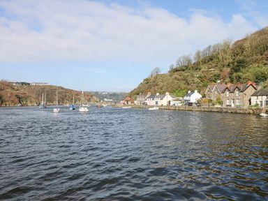 A coastal village with boats on water and houses along the shore at Min-Y-Ffordd in Dinas Cross
