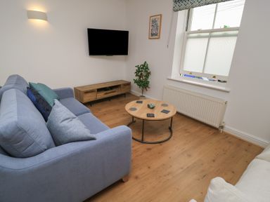 A living room with a sofa and television at Weyside in Weymouth