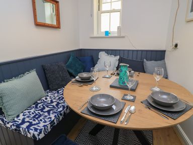 A dining room with a round table and cushions at Weyside in Weymouth