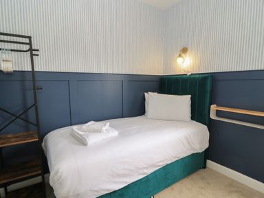 A bedroom with a bed and shelf at Weyside in Weymouth