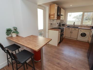 A kitchen with appliances and a table at 41 St. James Street Narberth