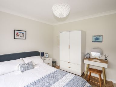 A bedroom with a bed a bedside table a wardrobe and a dressing table at The Palms in Abersoch