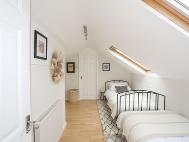 A bedroom with two single beds and a skylight window at The Palms in Abersoch