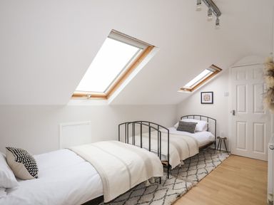 A bedroom with two single beds under skylight windows at The Palms in Abersoch