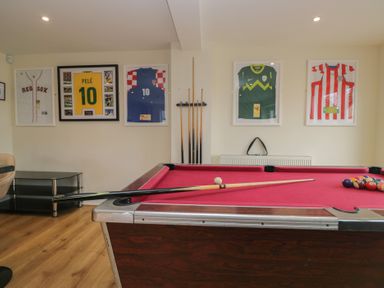 A games room with a pool table and framed sports jerseys at Whimhowe in Windermere