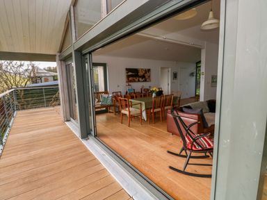 A dining room with a table and chairs seen from a deck at Green Shutters in Freshwater East near Lamphey