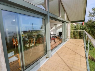 A living room with a deck view at Green Shutters in Freshwater East near Lamphey