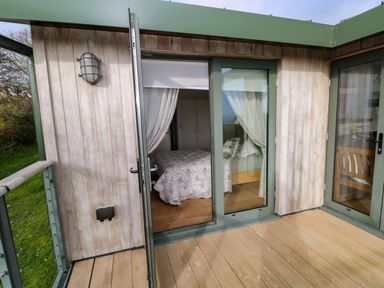 A bedroom with a bed and curtains at Green Shutters Freshwater East near Lamphey
