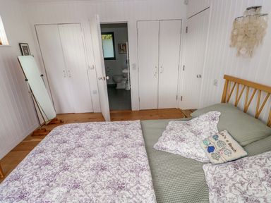 A bedroom with a bed and mirror at Green Shutters Freshwater East near Lamphey