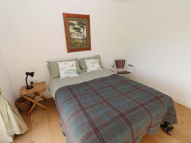 A bedroom with a bed and artwork at Green Shutters Freshwater East near Lamphey
