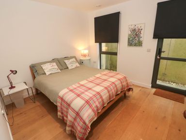 A bedroom with a bed and bedside table at Green Shutters in Freshwater East near Lamphey