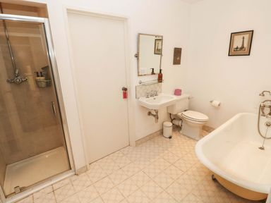 A bathroom with a shower, bathtub, sink and toilet at Green Shutters near Freshwater East