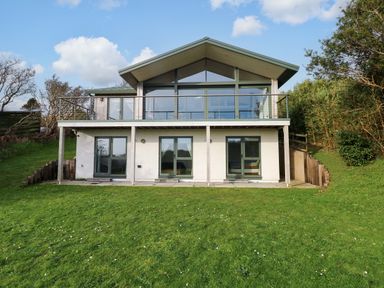 A house with a balcony and large windows at Green Shutters Freshwater East near Lamphey
