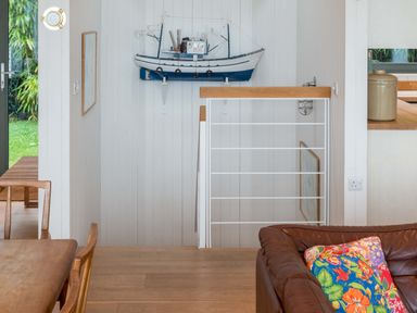 A living room with a model boat on the wall at Green Shutters near Freshwater East