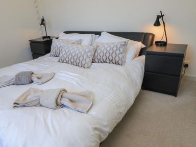 A bedroom with a bed and bedside tables at Bayview Cottage Southbourne