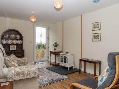 A living room with a sofa, armchair and coffee table at Aunty Junes Cottage Okehampton