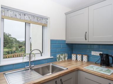 A kitchen with a sink and decorative containers at Aunty Junes Cottage Okehampton