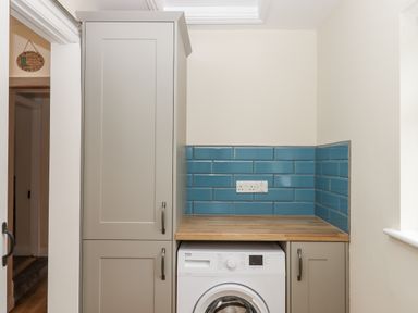 A utility room with a washing machine and cabinet at Aunty Junes Cottage Okehampton
