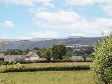 A view of houses and fields with hills in the background at Aunty Junes Cottage Okehampton