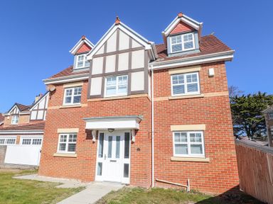 A brick house with white windows and a white front door at 9 Beckett Close in Colwyn Bay