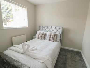A bedroom with a bed and pillows at 9 Beckett Close in Colwyn Bay