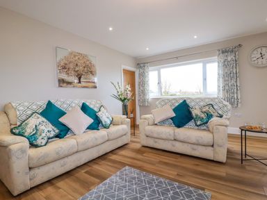 A living room with two sofas and patterned cushions at Little Hillside in Redruth