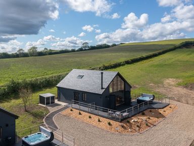 A small modern house with a deck and hot tubs in a rural area with fields at Hares Hill in Thornton-Le-Dale