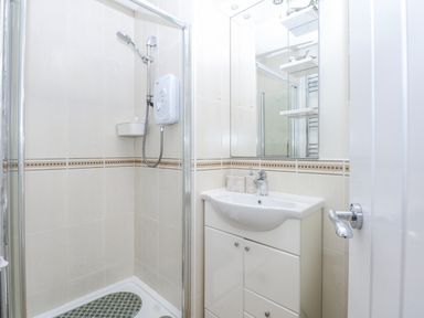 A shower and sink in a bathroom at Oakley View Apartment in Porthmadog
