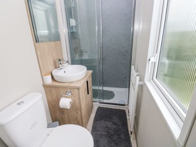 A bathroom with a toilet sink shower and window at Caldey Retreat in Hasguard Cross near Broad Haven