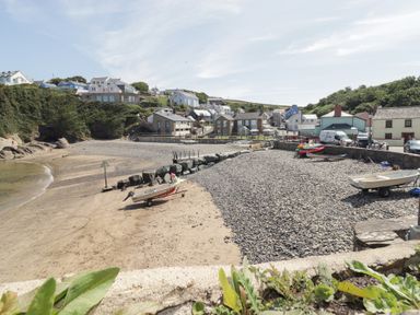A beach with boats and houses at Caldey Retreat near Hasguard Cross