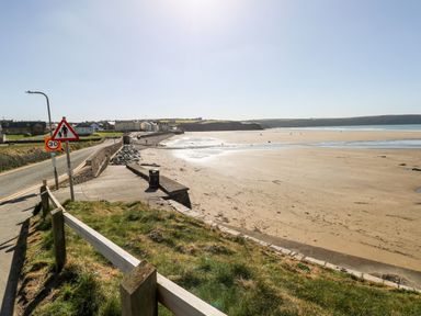 A beach with a road and signs at Caldey Retreat Hasguard Cross near Broad Haven