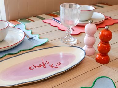 A dining table with plates bowls and glassware alongside salt and pepper shakers at Mavericks Wave in St Agnes