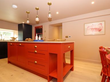 A kitchen with a red island counter and hanging lights at Mavericks Wave in St Agnes