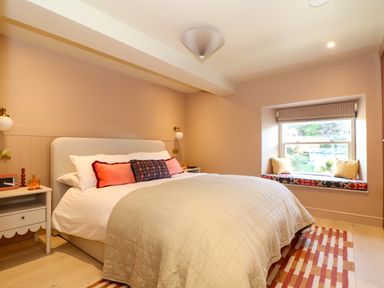 A bedroom with a double bed bedside tables and a window seat at Mavericks Wave in St Agnes