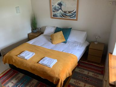 A bedroom with a double bed two bedside tables and framed art above the bed at Kernyk in Carn Brea near Pool