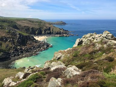 A coastal view with rocky cliffs green vegetation and a sandy beach at Kernyk in Carn Brea near Pool