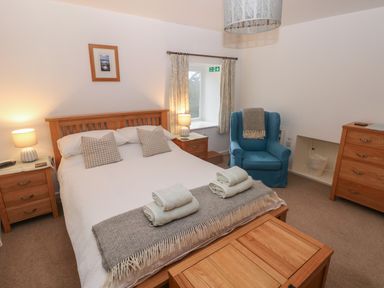 A bedroom with a double bed and bedside tables with lamps at Wood Cottage in Solva