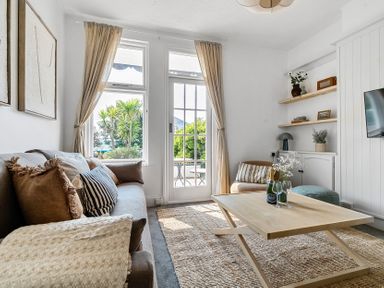 A living room with a sofa and table at Palm House in Newquay