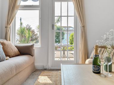 A living room with a sofa and a table at Palm House in Newquay