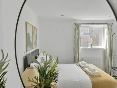 A bedroom with a bed and wall art at Palm House in Newquay