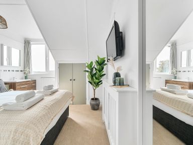 A bedroom with bed and television at Palm House in Newquay