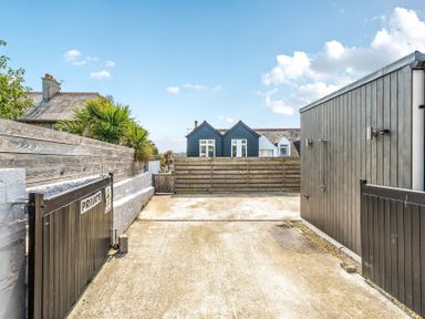 An outdoor driveway with a gate and shed at Palm House in Newquay