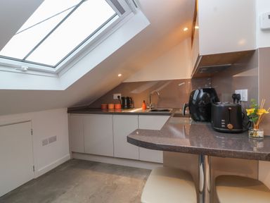 A kitchen with slanted ceiling skylight cabinets countertop and small appliances at The Halt in Maiden Newton