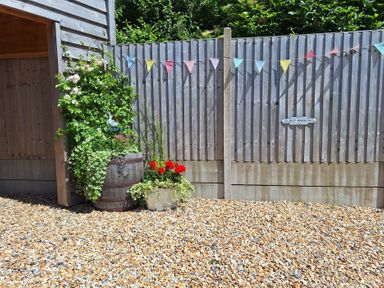 An outdoor area with flowers and a sign that reads guest parking at The Halt in Maiden Newton