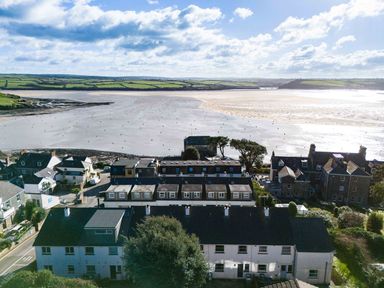 A coastal village with houses and a view of a wide estuary and distant hills at Slipway 14 in Rock